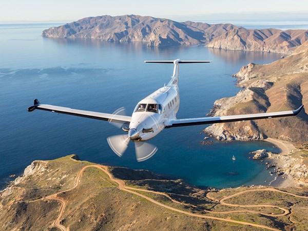 Propeller plane flying over coastal land