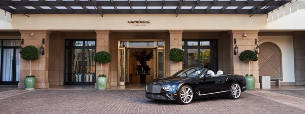 Black Bentley convertible parked in front of the exterior of The Maybourne Beverly Hills hotel