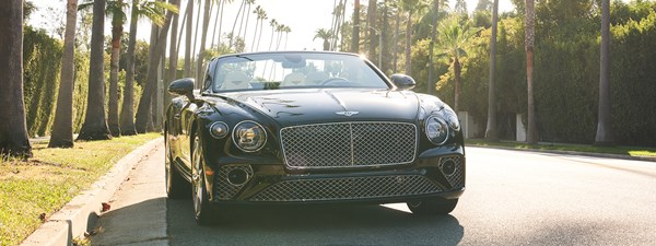 Bentley convertible parked on a tree lined street