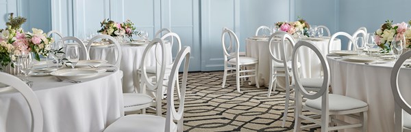 Beverly event space at Maybourne Beverly Hills set up as a reception room with round dining tables.