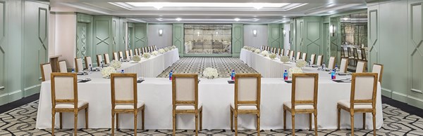 Chairs set up in a horseshoe configuration around a large desk in a meeting room