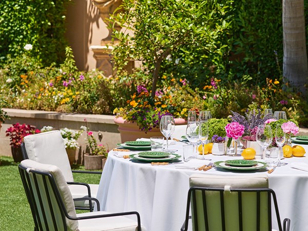 A round table with a white tablecloth and chairs arranged around it in the Garden Terrace