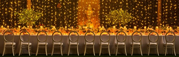 Long rectangular dining table with dangling lights at The Garden Terrace at The Maybourne Beverly Hills