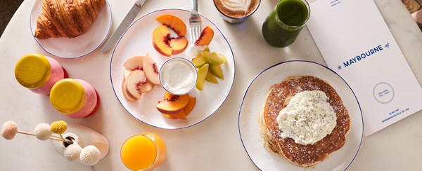 Breakfast dishes and a paper menu on a cafe table