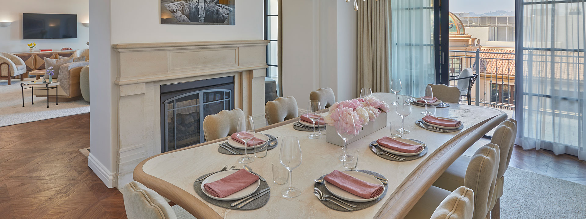 Dining table in hotel suite with sliding doors opening to a balcony